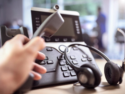 VOIP headset headphones and dialing a telephone in call center office concept for communication, it support, call center and customer service help desk